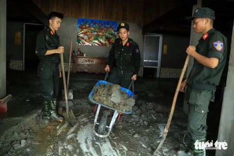 Vụ bục cống xả hồ thải nhà máy đồng Tả Phời: ‘Sự cố không mong muốn xảy ra nhưng nó đã xảy ra…’ - Ảnh 3. Cảnh sát cơ động hỗ trợ người dân thu dọn bùn thải