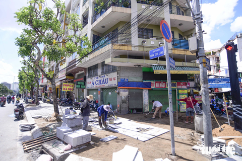 Công nhân lót đá trên vỉa hè đường Phan Xích Long trưa 10-8 Công nhân lát đá trên vỉa hè đường Phan Xích Long vào ngày 10-8 - Ảnh: QUANG ĐỊNH