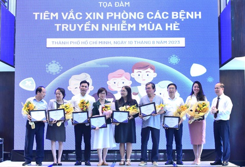 Tọa đàm " Tiêm vắc xin phòng các bệnh truyền nhiễm mùa hè" - Ảnh 3. Các chuyên gia nhận hoa từ ban tổ chức - Ảnh: DUYÊN PHAN