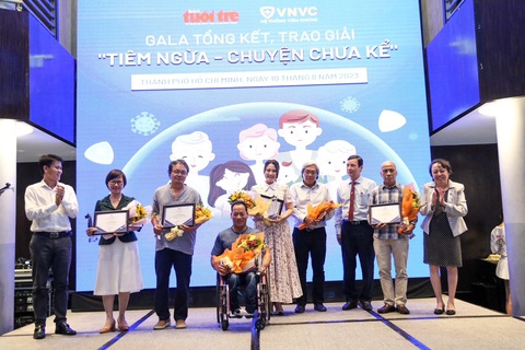 Gala trao 147 giải thưởng cho các tác giả tham gia cuộc thi 'Tiêm ngừa - Chuyện chưa kể' - Ảnh 11. Ông Võ Hùng Thuật, giám đốc Trung tâm truyền thông báo Tuổi Trẻ, tặng hoa cho ban giám khảo - Ảnh: PHƯƠNG QUYÊN