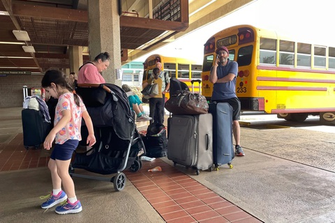 Hàng ngàn du khách vạ vật ở sân bay để trốn cháy rừng Hawaii - Ảnh 7. Xe buýt của các trường học được trưng dụng làm phương tiện trung chuyển du khách từ các trạm trú ẩn ra sân bay - Ảnh: NEW YORK TIMES