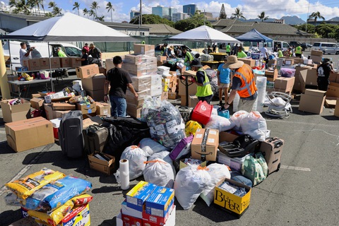 Cháy rừng thế kỷ ở Hawaii: 89 người chết, gốc cây bị thiêu từ bên trong lòng đất - Ảnh 2. Các tình nguyện viên tập kết hàng cứu trợ ở Honoluu, chuẩn bị đưa đến cho người dân tại Maui - Ảnh: REUTERS