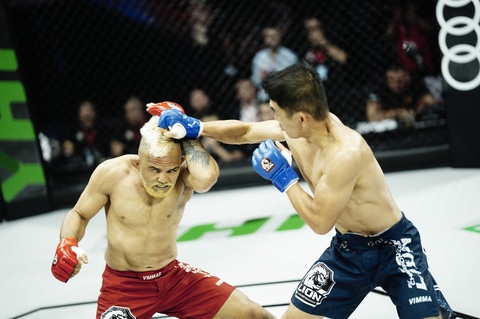 Sau tình huống né đòn đá cao, Robson lập tức vòng sang sau và kiểm soát được lưng của Huy Hoàng, ngay sau đó võ sĩ này đã thực hiện thành công kỹ thuật siết cổ sau giành chiến thắng ở hạng cân 60kg - Ảnh: BTC Sau tình huống né đòn đá cao, Robson lập tức vòng sang sau và kiểm soát được lưng của Huy Hoàng, ngay sau đó võ sĩ này đã thực hiện thành công kỹ thuật siết cổ sau giành chiến thắng ở hạng cân 60kg - Ảnh: BTC