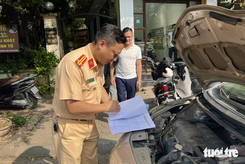 Đông nghịt người xếp hàng sang tên ô tô trước ngày biển số định danh có hiệu lực - Ảnh 6. Cảnh sát giao thông kiểm tra xe ô tô làm thủ tục sang tên đổi chủ - Ảnh: DANH TRỌNG