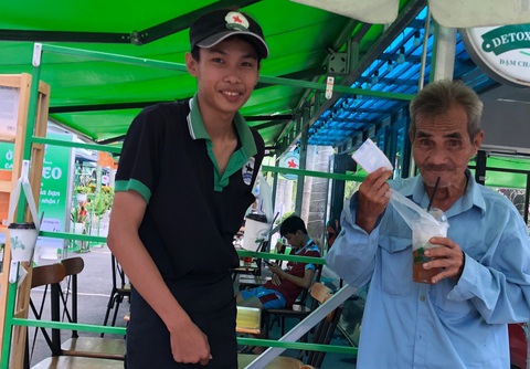 Cà phê treo nghĩa tình đem lại nụ cười cho bà con bán vé số - Ảnh 1. Một cụ ông bán vé số nhận ly nước giải khát của 'cà phê treo' tại TP Cao Lãnh - Ảnh: TỐNG DOANH