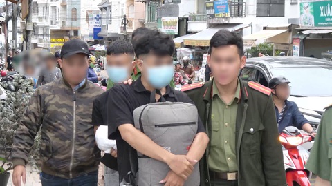 Quảng cáo khiêu dâm giữa trung tâm Đà Lạt để lừa đảo người tò mò - Ảnh 3. Hai thanh niên bị bắt quả tang với hàng ngàn tờ rơi chưa kịp đi rải - Ảnh: Công an cung cấp