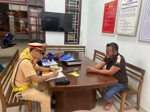 Ô tô khách dừng giữa đường, lo có người gặp nạn, CSGT tới hỗ trợ thì phát hiện tài xế ‘nhậu mệt’ - Ảnh 1. Lực lượng CSGT làm việc với tài xế xe khách dừng giữa đường và bỏ chạy, vượt đèn đỏ... - Ảnh: H.B.