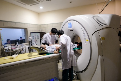 Các bác sĩ thực hiện kỹ thuật thăm khám cho bệnh nhân - Ảnh: NAM TRẦN Các bác sĩ thực hiện kỹ thuật chụp cắt lớp cho bệnh nhân - Ảnh: NAM TRẦN