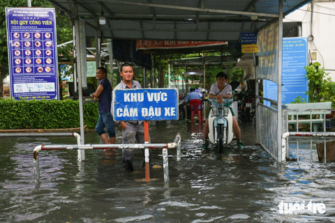 Mưa ngập ở TP.HCM: Đường mênh mông nước, có người dùng thuyền để đi - Ảnh 5. “Tôi là nhân viên giữ xe đã lâu nên quen với chuyện ngập nước như cơm bữa ở đây. Cứ mỗi lần có mưa lớn, thậm chí chỉ mưa vừa khoảng 20 phút thì công viên đã ngập lênh láng”, anh Thìn, làm bảo vệ giữ xe công viên Làng Hoa, nói