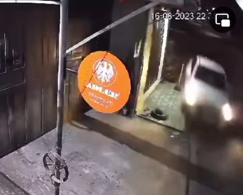 Bị ô tô tông chết khi ngồi hóng mát trước cửa nhà - Ảnh 1. Khoảnh khắc người đàn ông ngồi hóng mát trước cửa nhà bị ô tô con màu trắng phóng qua tông chết tại chỗ - Ảnh cắt từ video