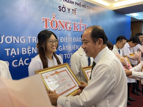 Giám đốc Sở Y tế khẳng định: ‘Sẽ đề xuất chính sách ưu tiên cho bác sĩ trẻ về cơ sở’ - Ảnh 1. Ông Tăng Chí Thượng - giám đốc Sở Y tế TP.HCM - tặng giấy khen cho các bác sĩ trẻ xuất sắc - Ảnh: HOÀNG LỘC