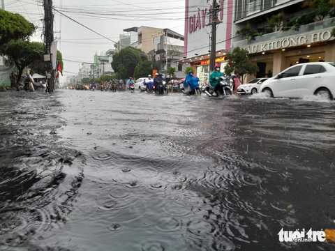 Đường phố Long Xuyên ngập nặng sau một cơn mưa lớn - Ảnh 2. Xe cộ như "bơi" giữa phố - Ảnh: CHÍ HẠNH