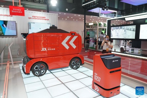 600 robot trên thế giới tham dự "Thế vận hội robot" tại Bắc Kinh - Ảnh 4. Một robot giao hàng trong nhà (phải) và robot chuyển phát nhanh thông minh (trái) - Ảnh: TÂN HOA XÃ