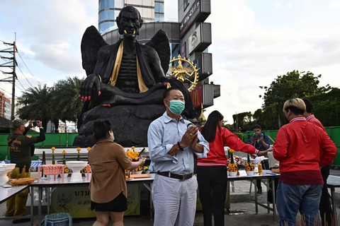 Người dân Bangkok yêu cầu di dời một bức tượng lạ - Ảnh 3. Tuy gây tranh cãi nhưng không ít người vẫn đến thờ cúng bức tượng đáng sợ này - Ảnh: AFP