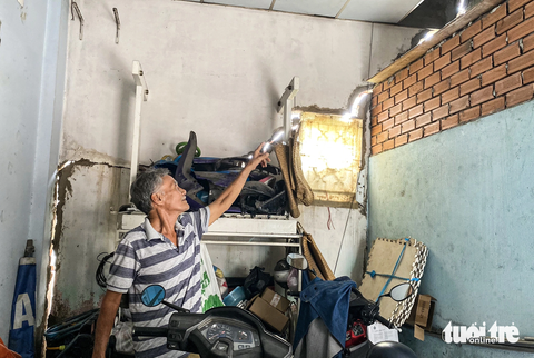 40 nhà dân gần công trình xây bờ kè 'bỗng nhiên' bị nứt toác - Ảnh 1. Ông Nguyễn Văn Quang (69 tuổi, ngụ tại số nhà 28 Phú Định) chỉ cho phóng viên thấy những vết nứt toác khắp căn nhà. Ông Quang đã dùng xi măng để trám tạm nhưng vẫn không ăn thua - Ảnh: TIẾN QUỐC