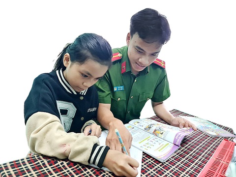 Cô bé con nuôi của các chú công an - Ảnh 1. Hân được trung úy Mai Hà Nam ân cần dạy bảo việc học