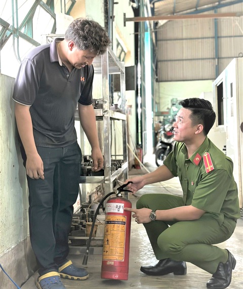 Trinh sát "khắc tinh" của tội phạm - Ảnh 1. Trung úy Nguyễn Minh Tài hướng dẫn bà con bảo quản thiết bị chữa cháy tại nhà - Ảnh: NVCC