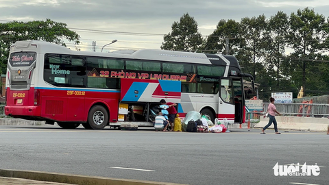 TP.HCM chỉ đạo khẩn Sở GTVT, địa phương cùng dẹp "xe dù, bến cóc" - Ảnh 1. Xe đón khách tấp nập ngay trước cổng bến xe Miền Đông mới (TP Thủ Đức) - Ảnh: THU DUNG