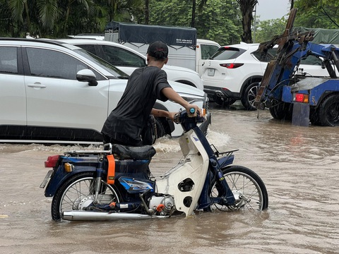 Mưa như trút nước, đường phố Hà Nội ngập lênh láng - Ảnh 5. Một người dân đi xe máy bị chết máy trên đường Võ Chí Công - Ảnh: PHẠM TUẤN