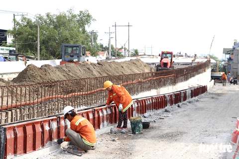 Công nhân đang thi công đổ bê tông bờ tường chân cầu Long Kiểng. Hiện tại, nền đường giảm tải, bệ đường đã hoàn thành - Ảnh: LƯU DUYÊN Công nhân đang thi công đổ bê tông bờ tường chân cầu Long Kiểng - Ảnh: LƯU DUYÊN