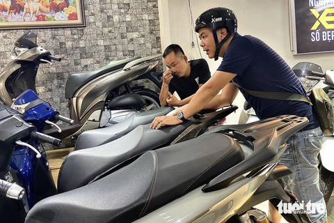 Thị trường xe biển số đẹp ở TP.HCM đại hạ giá - Ảnh 4. Một khách hàng đến xem xe máy biển số đẹp bày tỏ băn khoăn trước các thủ tục sang tên xe cũ - Ảnh: TIẾN QUỐC
