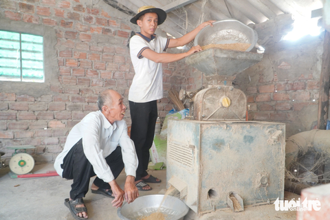 'Đốm sáng' trong căn nhà tối của Bảy Bôn - Ảnh 4. Phước cùng ông nội cặm cụi bên xưởng xay xát lúa - Ảnh: LÊ TRUNG