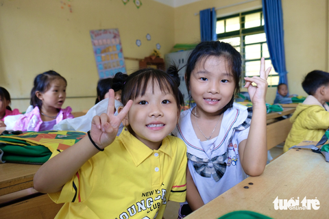 Đón học trò vùng lũ về trường trước ngày khai giảng - Ảnh 9. Sáng nay, thầy cô ở Hồ Bốn ai cũng hân hoan vì "vỡ kế hoạch", không chỉ học sinh khối 1, 6 mà các em học sinh các khối học khác cũng xuống tựu trường. "Các em đến trường đông vui, thầy cô vất vả một chút nhưng "có khí thế" lắm" - một thầy giáo không giấu được niềm vui. Trong ảnh, em Bảo An, Nhã Yên hào hứng sẵn sàng vào lớp 1 - Ảnh: NGUYÊN BẢO