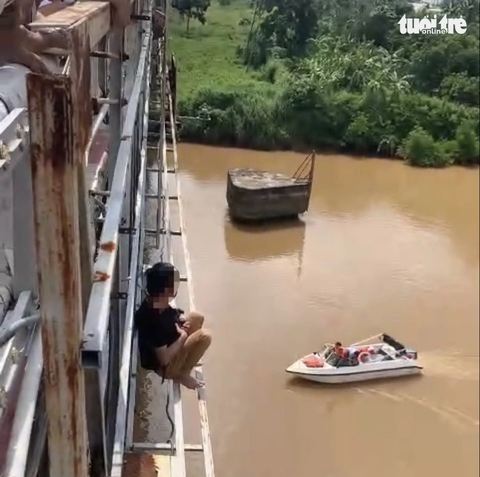 Người đàn ông ôm con chó định nhảy cầu khiến lực lượng công an và người dân phải triển khai ứng cứu - Ảnh: T.D. Người đàn ông ôm con chó định nhảy cầu khiến lực lượng công an và người dân phải ứng cứu - Ảnh: T.D.