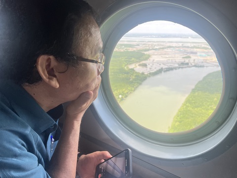 Sau chuyến bay khảo sát, Bí thư Nguyễn Văn Nên trăn trở giải pháp khai thác hết nguồn lực đất đai - Ảnh 3. Suốt buổi khảo sát, Bí thư Nguyễn Văn Nên dành hầu hết thời gian để quan sát, quay phim, chụp hình các khu vực quận, huyện của TP.HCM nhìn từ trên cao - Ảnh: TIẾN LONG