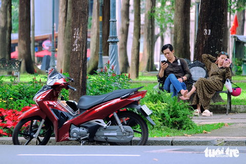 - Ảnh 1. Công viên 30 Tháng 4 (quận 1) ở ngay trung tâm TP.HCM, thu hút nhiều người dân, du khách đến dạo chơi, hóng mát nhưng không có bãi giữ xe. Thông thường người dân sẽ gửi xe ở bãi xe Dinh Độc Lập. Nhưng thực tế, nhiều người chọn đậu xe ngay dưới lòng đường và ngồi ghế đá trông xe.