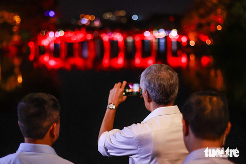 Thủ tướng Singapore Lý Hiển Long dạo hồ Gươm, ăn đồ Việt - Ảnh 3. Thủ tướng Lý Hiển Long chụp ảnh cầu Thê Húc dưới ánh đèn vào buổi tối - Ảnh: NGUYỄN KHÁNH
