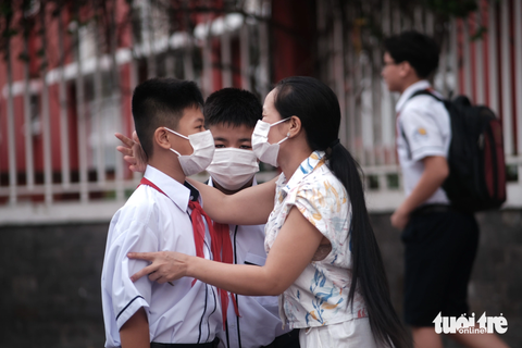 Học sinh TP.HCM háo hức đón chào năm học mới - Ảnh 6. Chị Ngọc Anh ôm hôn động viên hai con bước năm học mới - Ảnh: NGỌC PHƯỢNG
