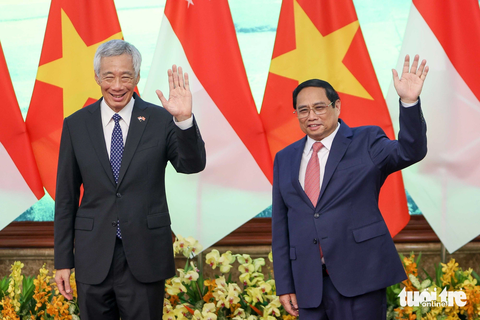 Việt Nam và Singapore ký 7 văn kiện hợp tác, nghiên cứu nâng cấp lên Đối tác chiến lược toàn diện - Ảnh 1. Thủ tướng Phạm Minh Chính và Thủ tướng Singapore Lý Hiển Long vẫy tay chào báo chí trước khi bước vào hội đàm - Ảnh: NGUYỄN KHÁNH