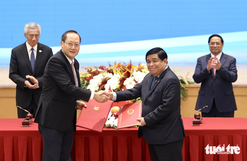 Việt Nam và Singapore ký 7 văn kiện hợp tác, nghiên cứu nâng cấp lên Đối tác chiến lược toàn diện - Ảnh 4. Bộ trưởng Bộ Kế hoạch và Đầu tư Nguyễn Chí Dũng (phải) trao đổi văn kiện với Bộ trưởng Bộ Nhân lực kiêm Bộ trưởng thứ hai Bộ Công Thương Singapore Tan See Leng về sửa đổi Hiệp định khung kết nối hai nền kinh tế - Ảnh: NGUYỄN KHÁNH