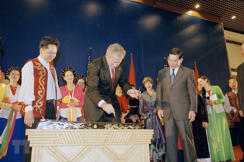 Nhìn lại chuyến thăm của các tổng thống Mỹ tới Việt Nam - Ảnh 3. Tổng thống Mỹ George W.Bush chơi đàn bầu - nhạc cụ truyền thống của Việt Nam - trong bữa tiệc chiêu đãi do Chủ tịch nước Nguyễn Minh Triết tổ chức tại Trung tâm Hội nghị quốc tế ở Hà Nội, khi ông Bush có chuyến thăm chính thức Việt Nam từ ngày 17 tới 20-11-2006 - Ảnh: TTXVN