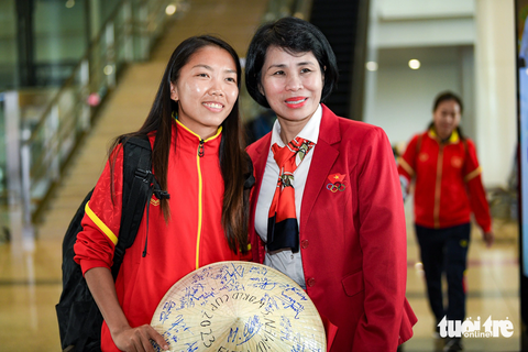Huỳnh Như khóc khi về nước, hy vọng tuyển nữ Việt Nam sẽ lại được dự World Cup - Ảnh 2. Phó cục trưởng Cục Thể dục thể thao Lê Thị Hoàng Yến (phải) chụp ảnh cùng Huỳnh Như tại sân bay Nội Bài - Ảnh: NAM TRẦN