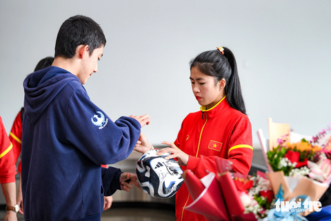 Huỳnh Như khóc khi về nước, hy vọng tuyển nữ Việt Nam sẽ lại được dự World Cup - Ảnh 6. Thanh Nhã tranh thủ ký tặng người hâm mộ tại khu vực chờ lấy hành lý - Ảnh: NAM TRẦN