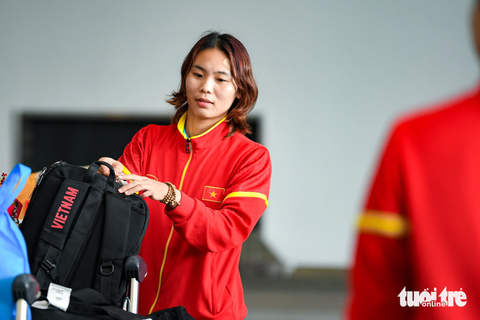Huỳnh Như khóc khi về nước, hy vọng tuyển nữ Việt Nam sẽ lại được dự World Cup - Ảnh 7. Tiền đạo Phạm Hải Yến sắp xếp đồ đạc, hành lý lên xe đẩy - Ảnh: NAM TRẦN