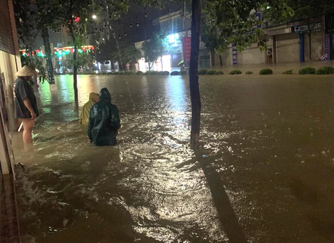 Điện Biên Phủ ngập sâu cả mét sau mưa lớn, nước tràn vào hàng loạt nhà dân - Ảnh 5. Người dân bì bõm di chuyển trên đường Võ Nguyên Giáp - Ảnh: THU HẰNG