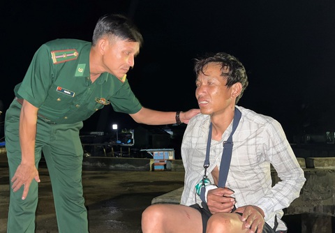 Tàu Trung Quốc truy đuổi tàu cá Việt Nam ở Hoàng Sa, phun vòi rồng làm 2 ngư dân bị thương - Ảnh 4. Cán bộ biên phòng hỏi thăm sức khỏe của ngư dân Hoanh - Ảnh: T.M.
