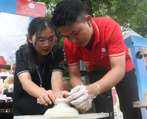 Đoàn Thị Trúc Phương (bìa trái) trải nghiệm làm gốm tại gian hàng gốm Bát Tràng - Ảnh: THÁI THÁI Đoàn Thị Trúc Phương (trái) trải nghiệm làm gốm tại gian hàng gốm Bát Tràng - Ảnh: THÁI THÁI