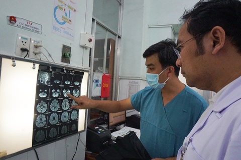 Lần đầu tiên Việt Nam cứu ca tay chân miệng độ 4 bằng ECMO - Ảnh 1. BS.CKII Đỗ Châu Việt (phải) và bác sĩ CKI Võ Thành Luân xem hình ảnh chụp MRI của bệnh nhi mắc tay chân miệng độ 4 - Ảnh: Bệnh viện cung cấp