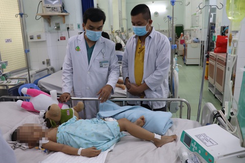 Lần đầu tiên Việt Nam cứu ca tay chân miệng độ 4 bằng ECMO - Ảnh 2. Bác sĩ CKI Võ Thành Luân, phó trưởng khoa hồi sức nhiễm và COVID-19 Bệnh viện Nhi đồng 2, trao đổi tình hình sức khỏe của bé với người nhà - Ảnh: Bệnh viện cung cấp