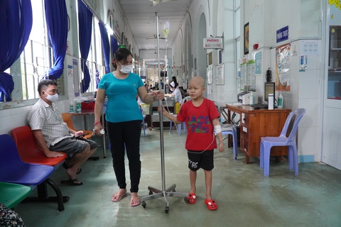 Cậu bé mắc ung thư cười khoái chí được làm lính cứu hỏa - Ảnh 4. Cùng mẹ, bé Quân luôn lạc quan khi điều trị tại khoa ung bướu huyết học của Bệnh viện Nhi đồng 2 (TP.HCM) - Ảnh: BVCC