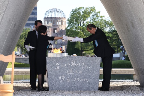 Nhật Bản nói lo ngại việc Nga dọa dùng vũ khí hạt nhân tại lễ tưởng niệm ở Hiroshima - Ảnh 3. Thị trưởng thành phố Hiroshima, ông Matsui Kazumi (bìa phải) và đại diện gia đình nạn nhân lưu giữ cuốn sổ ghi lại tên các nạn nhân trong thảm họa bom nguyên tử năm 1945 - Ảnh: AFP
