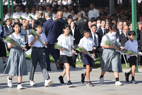Nhật Bản nói lo ngại việc Nga dọa dùng vũ khí hạt nhân tại lễ tưởng niệm ở Hiroshima - Ảnh 6. Các em học sinh Nhật Bản dâng hoa tưởng niệm các nạn nhân trong thảm họa - Ảnh: AFP