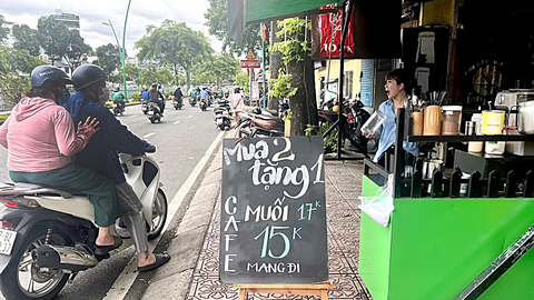 Cà phê muối - uống nhiều dễ mắc bệnh - Ảnh 1. Một khách hàng đang gọi mua một ly cà phê muối tại một tiệm cà phê ở TP.HCM - Ảnh: THÙY DƯƠNG