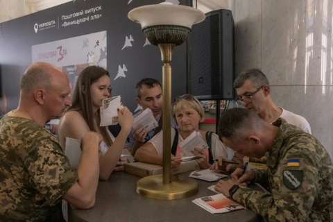 Ukraine in tem có hình máy bay F-16 để ‘hủy diệt cái ác’ - Ảnh 1. Người dân Ukraine xếp hàng mua tem mới có chữ ký của một phi công Ukraine - Ảnh: AFP