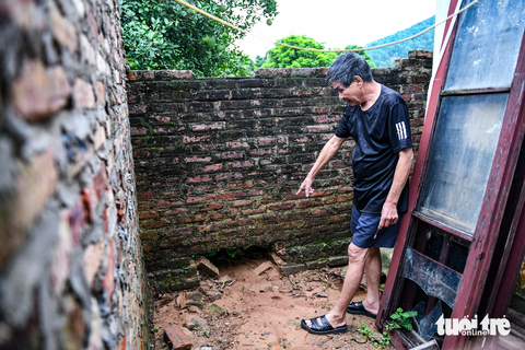 Loạt homestay 'nuốt chửng' đất rừng ở Sóc Sơn nơi đất đá vùi lấp nhiều xe sang - Ảnh 5. Nhưng nước chảy quá mạnh, kéo theo đất đá từ đồi cao nên sợ sập nhà, ông phải đập các lỗ ở tường để thoát nước - Ảnh: NAM TRẦN
