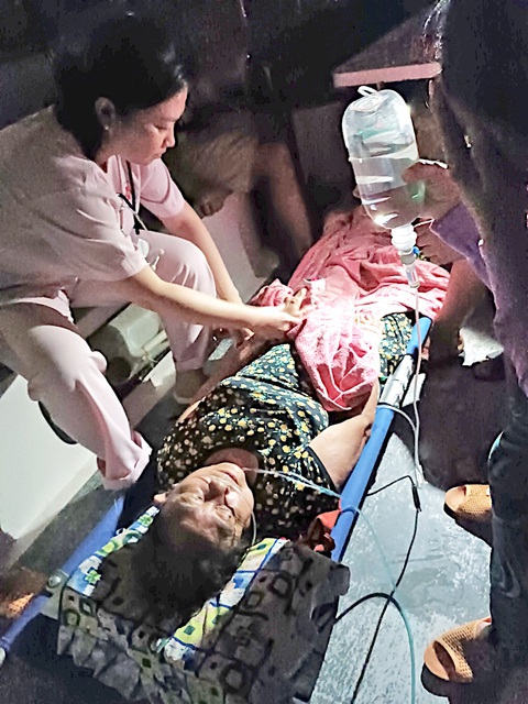Gian nan hành trình đi chữa bệnh - Kỳ 2: Đêm cấp cứu trên biển - Ảnh 2. Cụ N.T.T. (69 tuổi) được các y bác sĩ cùng người nhà sơ cứu vào ban đêm trong tình trạng suy hô hấp trên chiếc xe ba gác